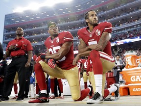 San Francisco 49ers safety Eric Reid (left) and quarterback Colin Kaepernick kneel during the national anthem before a game against the Los Angeles Rams on Sept. 12, 2016.