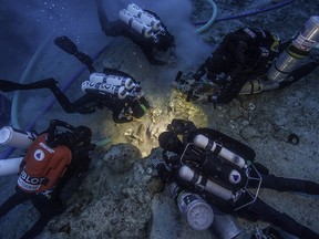 Archaeologists Brendan Foley, Theotokis Theodoulou and Alex Tourtas excavate the Antikythera Shipwreck skeletal remains, assisted by Nikolas Giannoulakis and Gemma Smith.