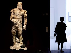 A woman walks past a Golem costume of the Malenki Theater in Tel Aviv as she arrives for a press presentation for the "Golem" exhibition at the Jewish Museum in Berlin, Germany, Sept. 22, 2016.