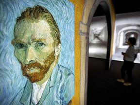 A visitor walks past an image of Van Gogh's "Self-Portrait" during the Meet Vincent Van Gogh exhibit in Beijing, China on June 15, 2016.