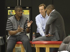 In this 2013 file photo, Toronto Raptors head coach Dwane Casey, then-general manager Jeff Weltman and president Masai Ujiri talk at a practice.