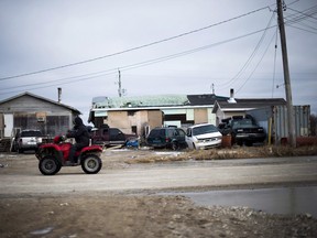 A man rides his ATV in Attawapiskat, Ont., on  April 20.