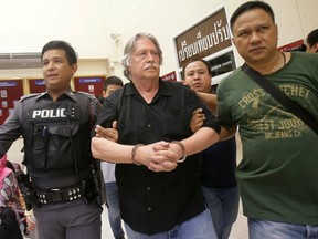 Police escort American James Douglas Eger, centre, one of three men arrested after the discovery of a body in a freezer.