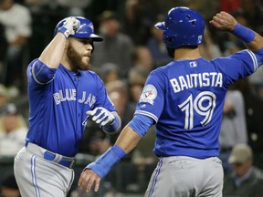 Toronto Blue Jays' Russell Martin is greeted at the plate by Jose Bautista after hitting a two-run homer in the fourth inning against the Mariners on Tuesday night in Seattle.