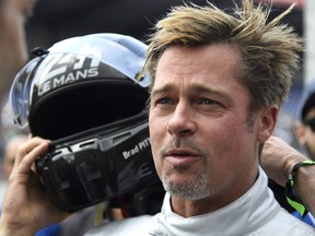 Brad Pitt removes his helmet after a full lap on the Le Mans 24 Hours circuit with a Pescarolo Prototype driven by Austria's Alex Wurz in June.