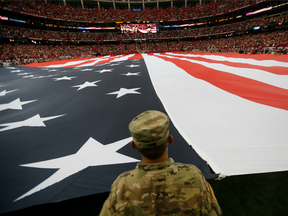 A member of the military holds a giant American flat during the national anthem before an NFL football game between the Atlanta Falcons and the Tampa Bay Buccaneers on Sept. 11.