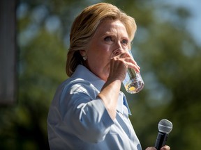 Hillary Clinton pauses to drink water after coughing as she speaks at the 11th Congressional District Labor Day festival at Luke Easter Park in Cleveland, Ohio, Monday, Sept. 5, 2016