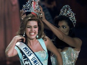 In this May 17, 1996, file photo, the new Miss Universe Alicia Machado of Venezuela reacts as she is crowned by the 1995 winner Chelsi Smith at the Miss Universe competition in Las Vegas.