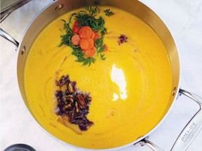 Carrot soup is topped with fresh carrots and pecans sautéed in browned butter.