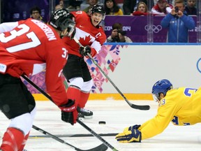 Sidney Crosby (centre) feeds a pass to Patrice Bergeron (left) during the 2014 Olympic gold-medal game in Sochi, Russia, on Feb. 23, 2014.