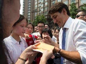 Canadian Prime Minister Justin Trudeau signs autographs for students as he visits the Nanyang Model Private High school in Shanghai, Friday September 2, 2016.