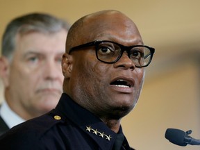 In this July 8, 2016 photo, Dallas police chief David Brown, front, and Dallas mayor Mike Rawlings, rear, talk with the media during a news conference in Dallas.