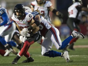 Ottawa Redblacks wide receiver Brad Sinopoli is tackled by Montreal Alouettes linebacker Bear Woods) during Ottawa's 19-14 win in Montreal on Thursday.