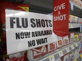 In this Sept. 16, 2014 file photo, a sign telling customers that they can get a flu shot at a Walgreens store is seen in Indianapolis.
