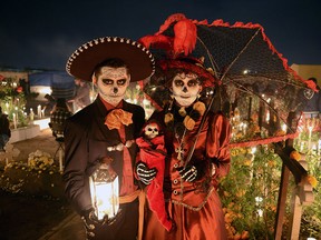 A couple pose at San Jeronimo Chicahualco cemetery in Metepec, Mexico in a November 2, 2013 file photo. Dia de los Muertos, or Day of the Dead, is a spectacle unto itself.