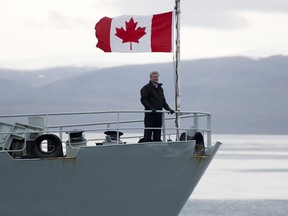Then-Prime Minister Stephen Harper stands on the slightly dented, slightly rusty bow of HMCS Kingston in 2014.