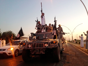 ISIL militants in a commandeered Iraqi security forces armoured vehicle in Mosul, Iraq, in 2014