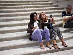 Two women take a selfie on the Spanish Steps a day after the site officially reopened to the public following a restoration, in Rome, Friday, Sept. 23, 2016.