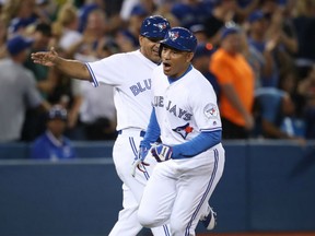 Ezequiel Carerra of the Toronto Blue Jays is congratulated by third-base coach Luis Rivera after hitting a game-winning, pinch-hit homerun in the eighth inning of Monday's MLB game against the Tampa Bay Rays at the Rogers Centre. The homer was the margin of victory in a 3-2 game.