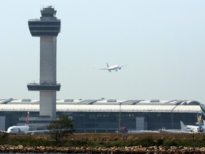 An aircraft flies past the control tower as it prepares to land at New York's John F Kennedy Airport, May 25, 2015.