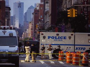 Members of the FBI and other law enforcement officers carry on investigations at the scene of Saturday's explosion in New York, early Sunday, Sept. 18, 2016.