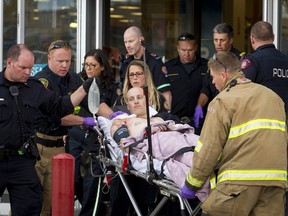 A police officer is wheeled on a stretcher out of the Sears in Marlborough Mall in Calgary, Alta., on Saturday, Sept. 17, 2016.