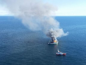 Fire burns on the fishing boat Atlantic Provider as a Canadian Coast Guard is near by in this image provided by the Canadian Armed Forces.
