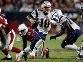 New England Patriots quarterback Jimmy Garoppolo scrambles against the Arizona Cardinals during the second half on Sunday in Glendale, Ariz.