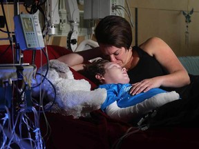 Jonathan Pitre is comforted by his mom, Tina, following a draining round of radiation on Sept. 7, 2016  at the University of Minnesota Masonic Children's Hospital