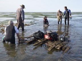 Researchers and archaeologists examine part of what they believe is the wreck of the Sainte-Anne in the St. Lawrence.