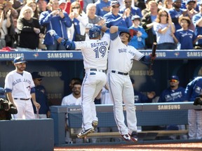 Jose Bautista (left) celebrates his fourth-inning home run with Troy Tulowitzki on Sept. 25.