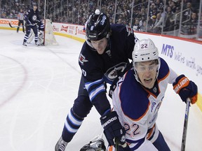 Winnipeg Jets defenceman Jacob Trouba (top) leans into Edmonton Oilers forward Adam Cracknell in Winnipeg during a game in March.