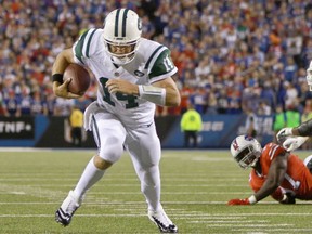 New York Jets' quarterback Ryan Fitzpatrck runs for yardage against the Buffalo Bills in the Thursday night NFL game at Orchard Park, N.Y. Fitzpatrick had a big game against his former team with 374 yards passing as the Jets improved their record to 1-1 with a 37-31 win over the winless (0-2) Bills.