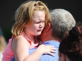 Lilly Chapman, 8, cries after being reunited with her father, John Chapman at Oakdale Baptist Church on Wednesday in Townville, South Carolina.
