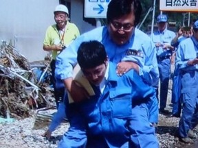A Japanese government official is under fire for riding on a colleague's back to get through a big puddle of water during his recent visit to a town devastated by a deadly storm
