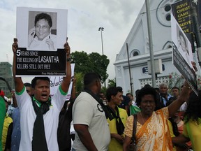 In this Jan. 28, 2014 file photo, a protestor holds a portrait of Lasantha Wickrematunge, a journalist who was killed, during a protest in Colombo, Sri Lanka