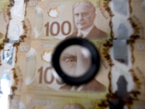 The image of Sir Robert Borden, former prime minister of Canada, is displayed on one hundred Canadian dollar banknotes in an arranged photograph in Toronto, Canada, on Monday, May 30, 2016. Canada's biggest banks forecast that more than twice as many of their energy loans will go bad as they had expected just a few months ago, after a recent rally in oil prices comes too late for some struggling companies to pay their obligations. Photographer: Brent Lewin/Bloomberg ORG XMIT: 643986993