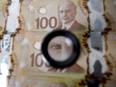 The image of Sir Robert Borden, former prime minister of Canada, is displayed on one hundred Canadian dollar banknotes in an arranged photograph in Toronto, Canada, on Monday, May 30, 2016. Canada's biggest banks forecast that more than twice as many of their energy loans will go bad as they had expected just a few months ago, after a recent rally in oil prices comes too late for some struggling companies to pay their obligations. Photographer: Brent Lewin/Bloomberg ORG XMIT: 643986993