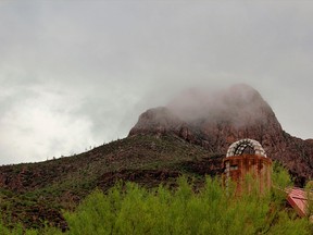 The All Creeds Chapel at the Sanctuary Cove in Marana, Ariz., is pictured as low clouds from an Aug. 9, 2016, monsoon swirl around adjacent Safford Peak. The peak has been a draw for people for centuries and is a highlight of a visit to the spiritual retreat below.