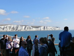 Tourists view the White Cliffs of Dover from a ferry travelling to Calais, France on Aug. 12, 2016.