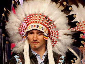 Prime Minister Justin Trudeau poses with painted face after being presented a headdress by Tom Heavenfire in an honouring ceremony at the Tsuut'ina Nation near Calgary, Ab., on Friday March 4, 2016.