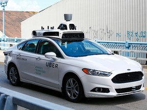 Uber employees test a self-driving Ford Fusion hybrid in Pittsburgh on Aug. 18.