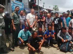 Foreign and local tourists posing for photographs with park rangers as they evacuate from Sembalun near the Barujari volcano in the Gunung Rinjani National Park on Sept. 28.