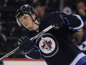 In this Dec. 12, 2013 file photo, Jacob Trouba shoots in warm-up before a game against the Colorado Avalanche.