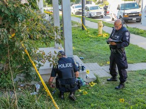 Police officers collect evidence at the scene of a homicide stabbing in Toronto on Tuesday.