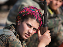 A Kurdish female soldier from the Syrian Democratic Forces rests after frontline action in November 2015 near the ISIL-held town of Hole in the autonomous region of Rojava, Syria.