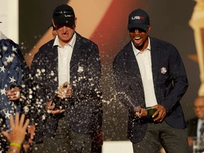 U.S. vice-captains Tiger Woods, right, and Jim Furyk spray champagne after winning the Ryder Cup last weekend.