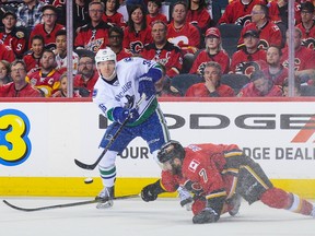 Vancouver's Jannik Hansen (left) flips a pass past Calgary's T.J. Brodie during the 2015 NHL playoffs.