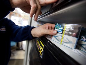 A corner store owner in St. Thomas, Ontario, Canada holds a package of cigarettes on March 12, 2012.