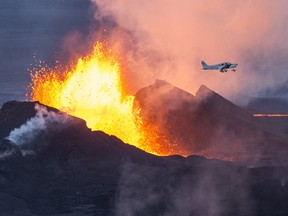 An aerial picture taken on September 14, 2014 shows a plane flying over the Bardarbunga volcano spewing lava and smoke in southeast Iceland.